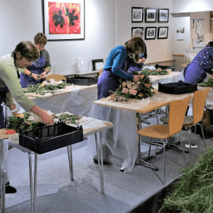 people making wreaths at christmas door wreath making workshop